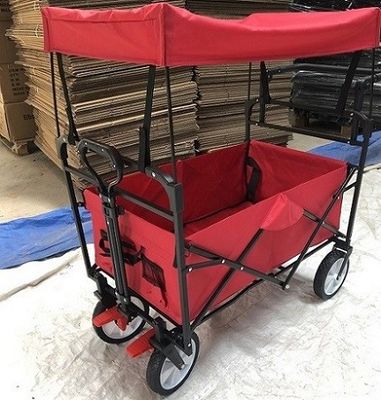 Los carros plegables del carro plegable rojo del carro con las ruedas cubren la manija del empuje